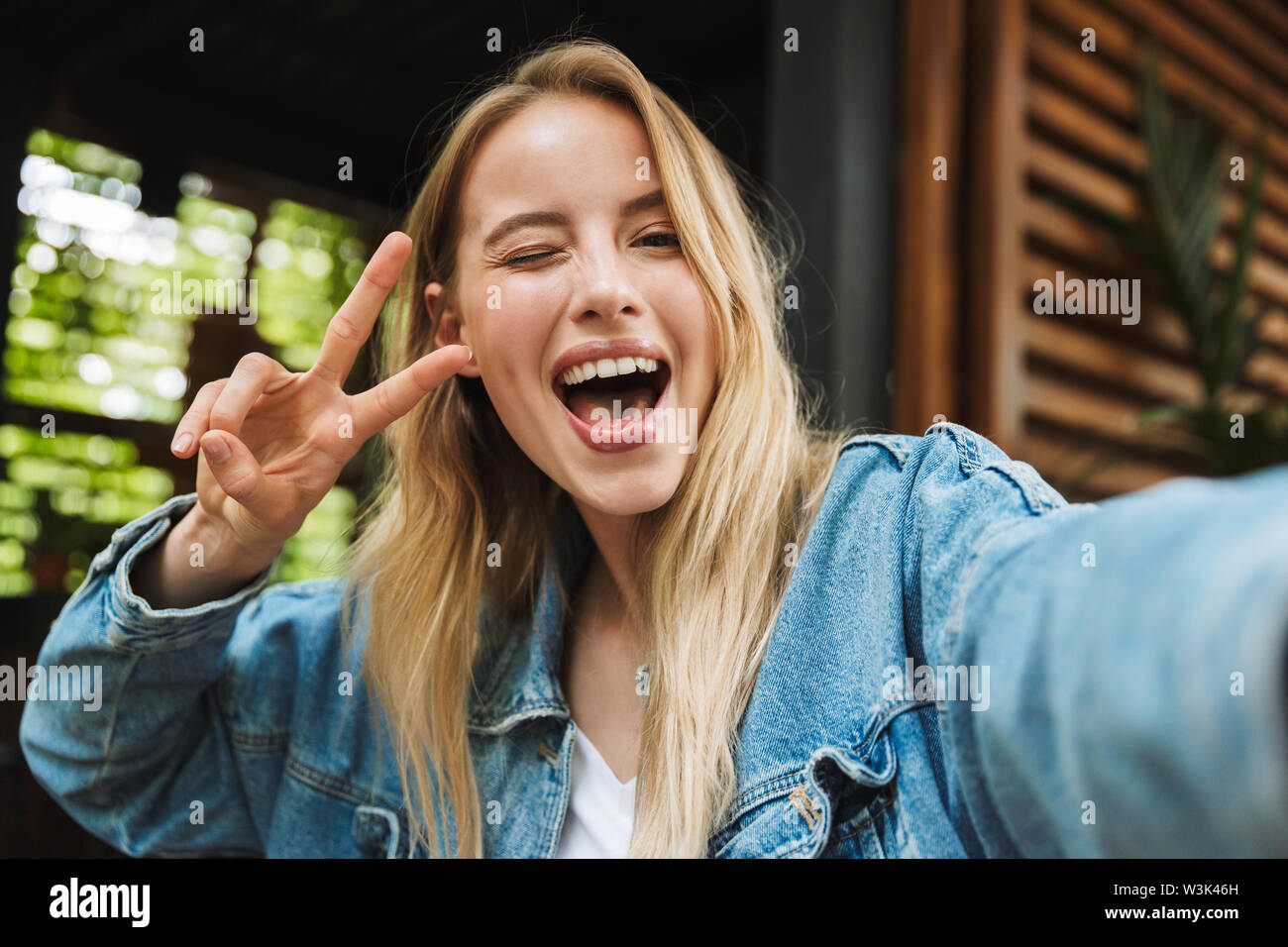 Image of amazing excited happy young woman posing outdoors in cafe take ...