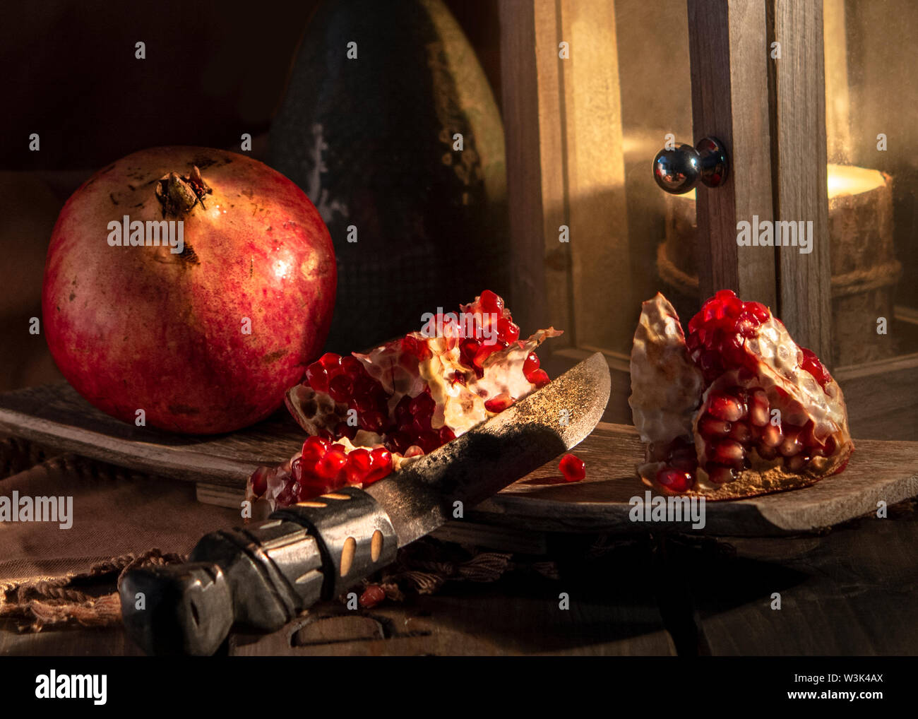 food still life picture with pomegranates and a lighted lantern Stock Photo