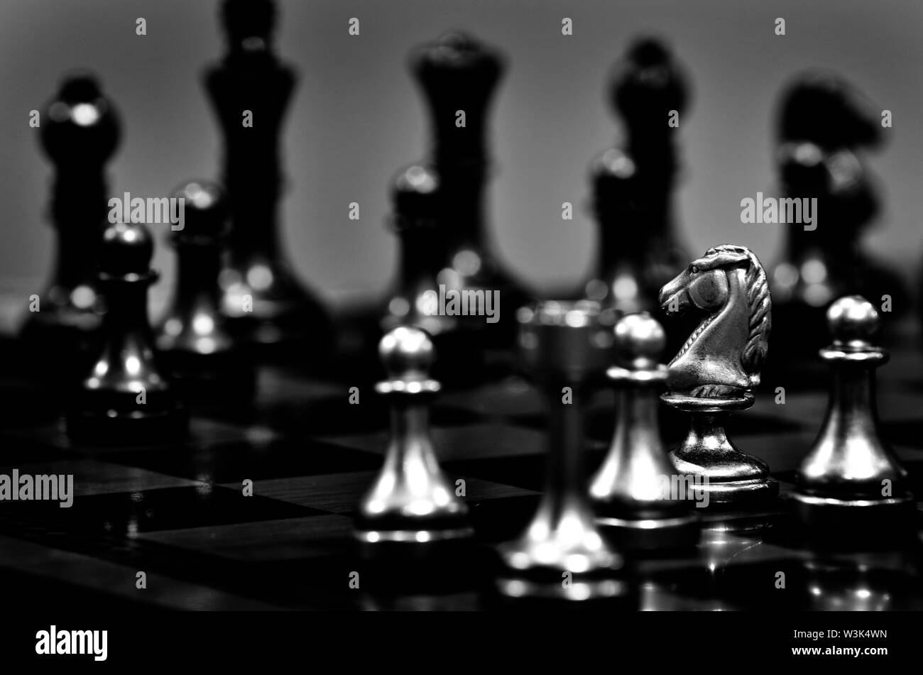 Chess board with white knight facing opponent in match Stock Photo