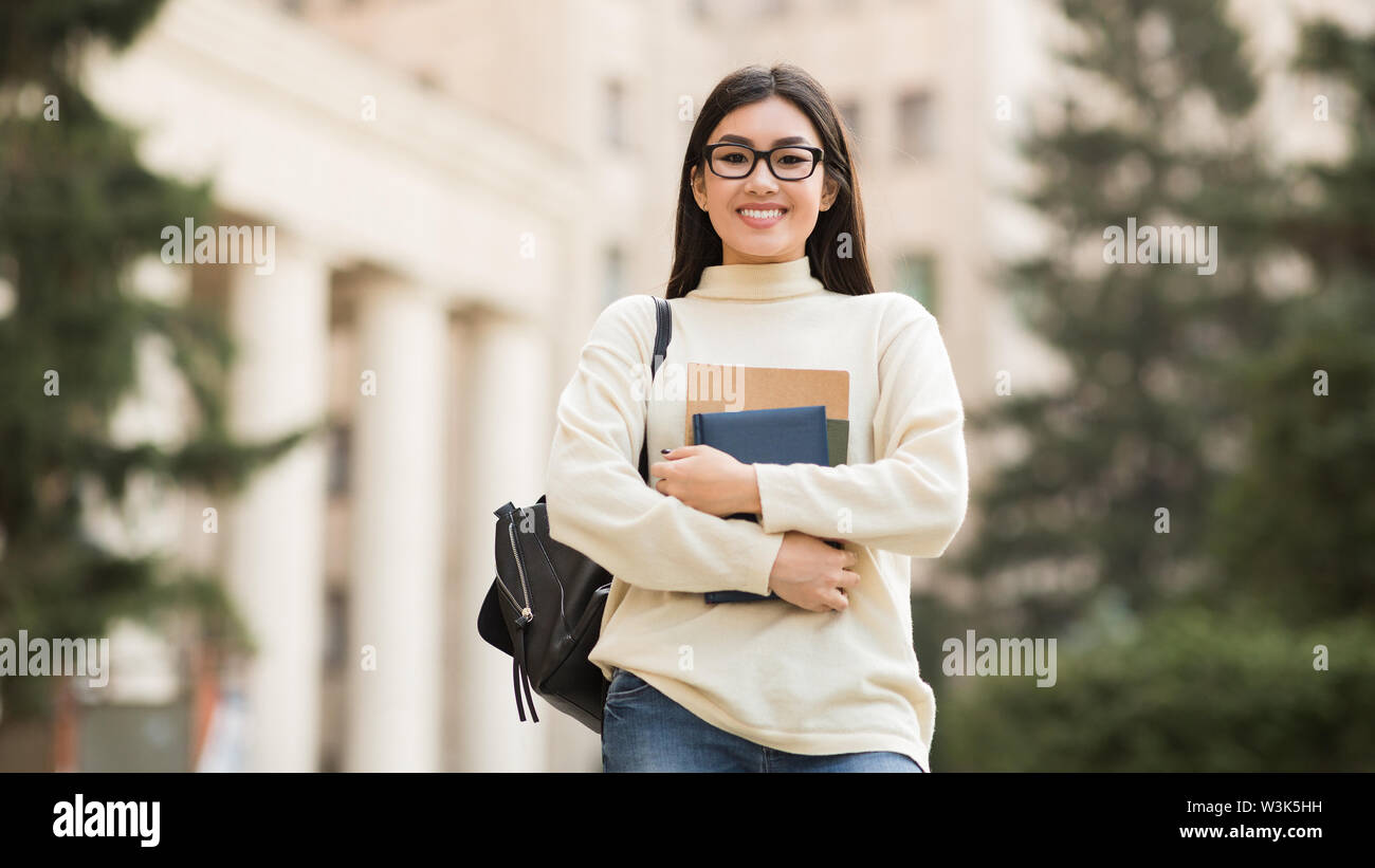 Education concept. Happy girl with books in campus Stock Photo