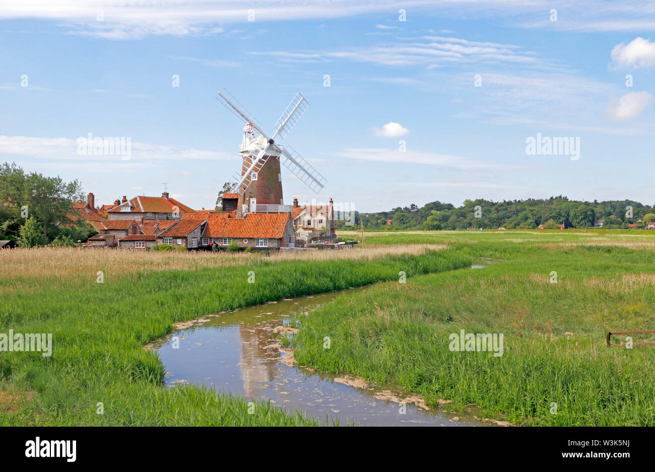 A view of Cley Windmill with the River Glaven flowing through reed beds on the North Norfolk coast at Cley-next-the-Sea, Norfolk, England, UK, Europe. Stock Photo