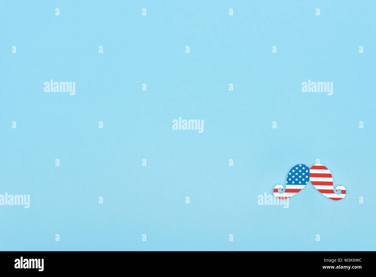 top view of mustache made of american flag on blue background with copy ...