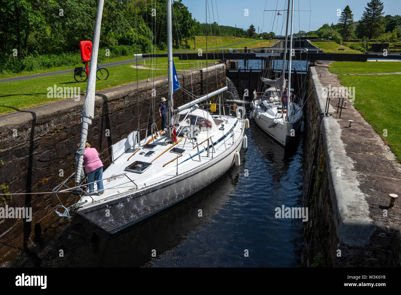 Two yachts within lock 10 as water level is lowered – Dunardry on Crinan Canal, Argyll and Bute, Scotland, UK Stock Photo