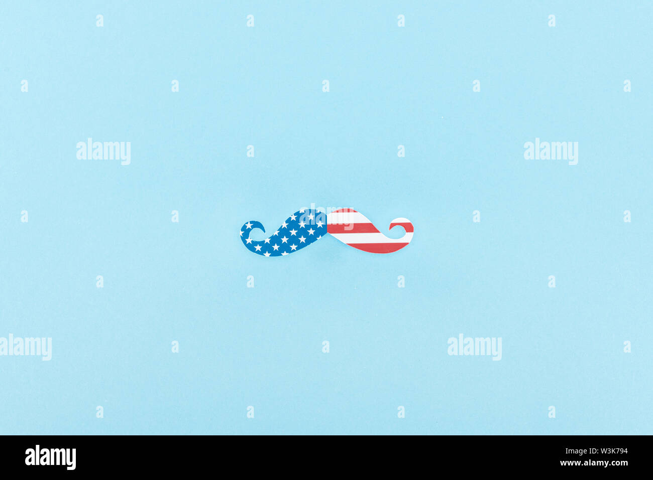 top view of paper cut mustache made of american flag on blue background ...