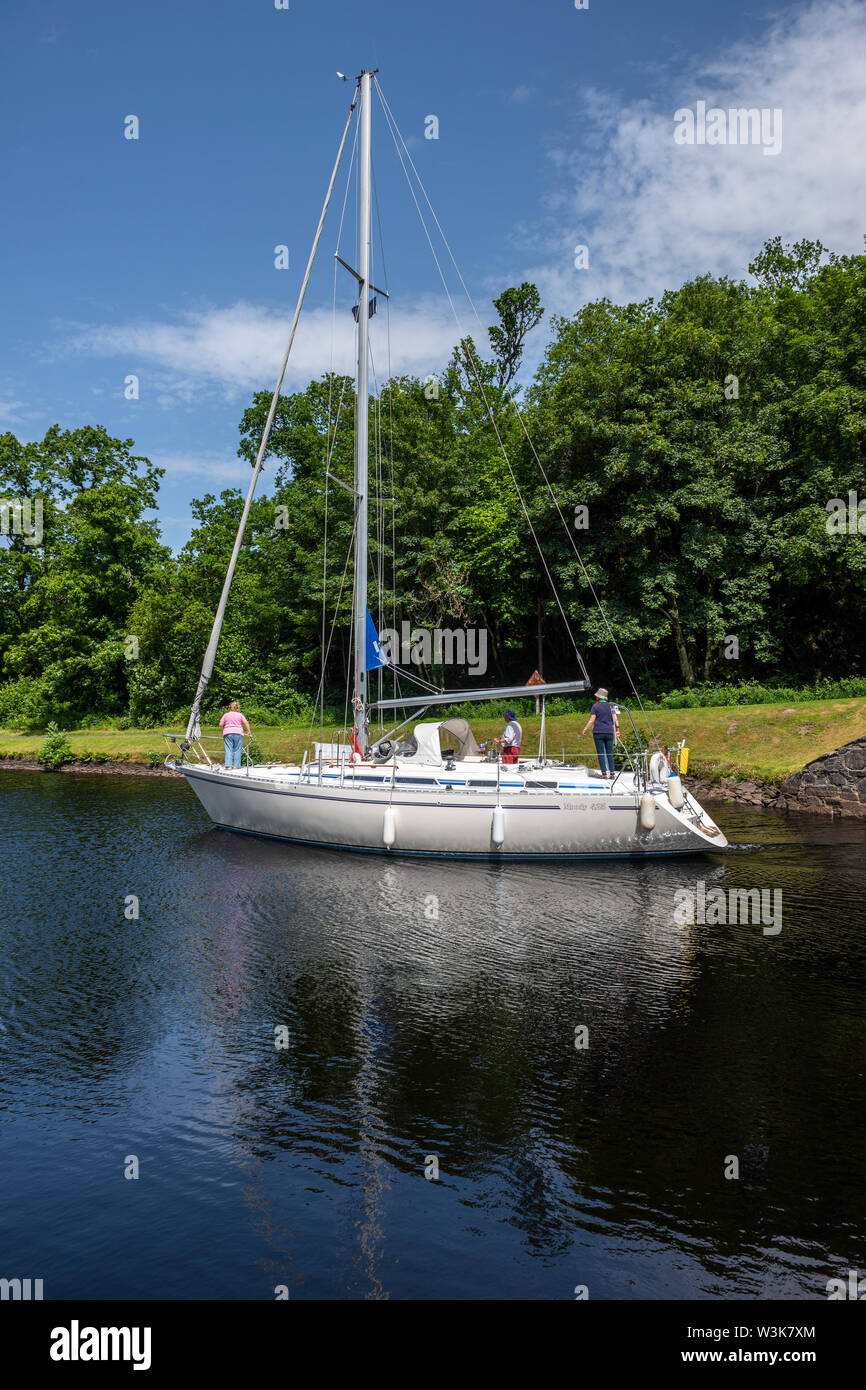 Yacht exiting lock 10 and heading west towards Crinan - Dunardry on Crinan Canal, Argyll and Bute, Scotland, UK Stock Photo