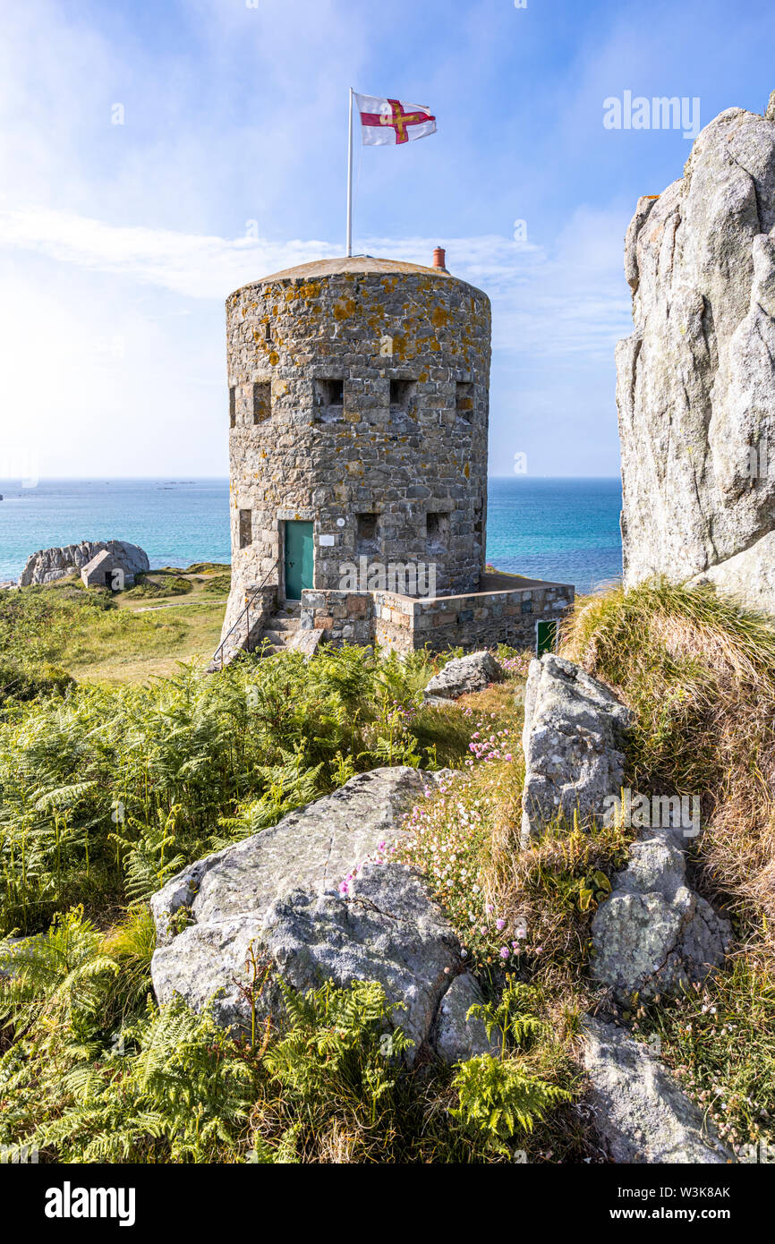 The Guernsey flag flying over Loophole Tower No 5 L'Ancresse (Nid de l'Herbe, Vale), Guernsey, Channel Islands UK - Built around 1778 - 79. Stock Photo