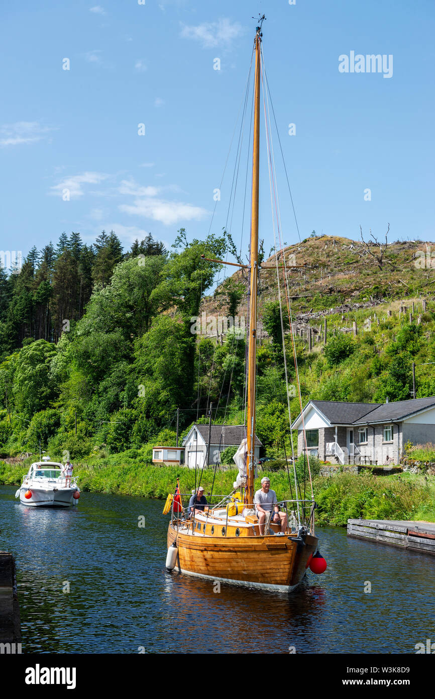 Wooden yacht approaching lock 8 at Cairnbaan on Crinan Canal, Argyll and Bute, Scotland, UK Stock Photo