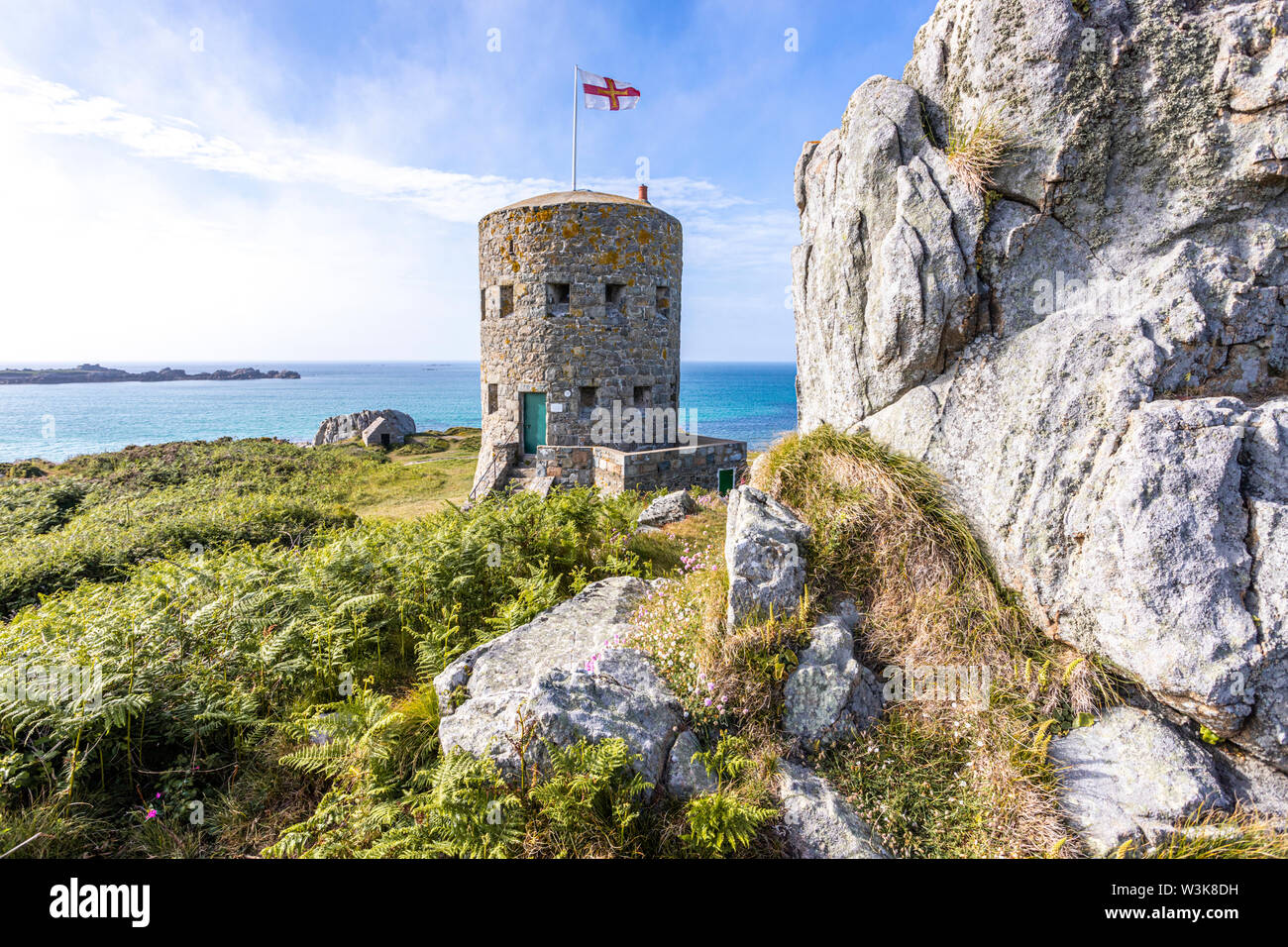 The Guernsey flag flying over Loophole Tower No 5 L'Ancresse (Nid de l'Herbe, Vale), Guernsey, Channel Islands UK - Built around 1778 - 79. Stock Photo