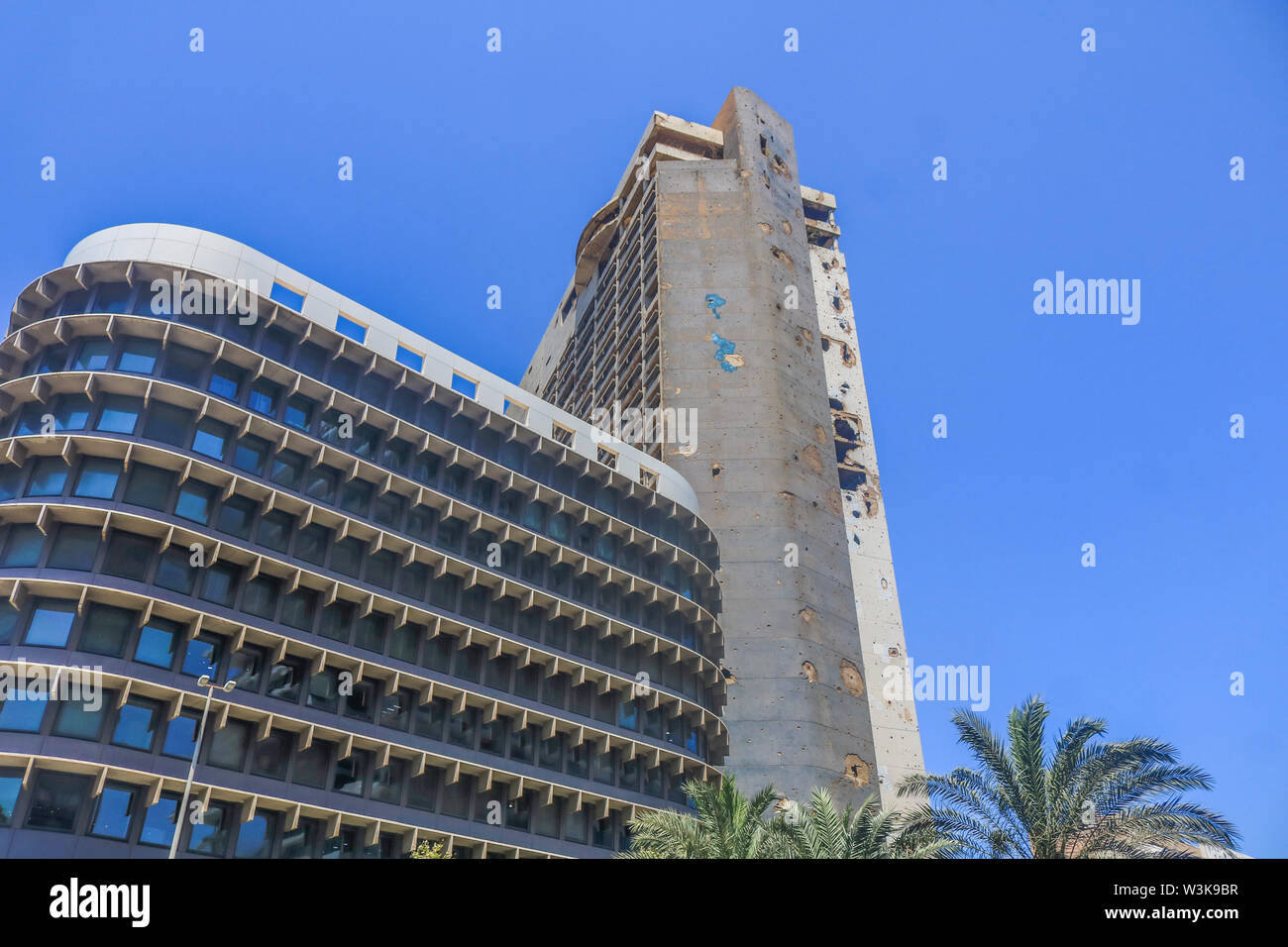 July 16, 2019 - Beirut, Lebanon - A modern office building adjacent to the former Holiday Inn hotel with the scars of the Lebanese civil war. (Credit Image: © Amer Ghazzal/SOPA Images via ZUMA Wire) Stock Photo