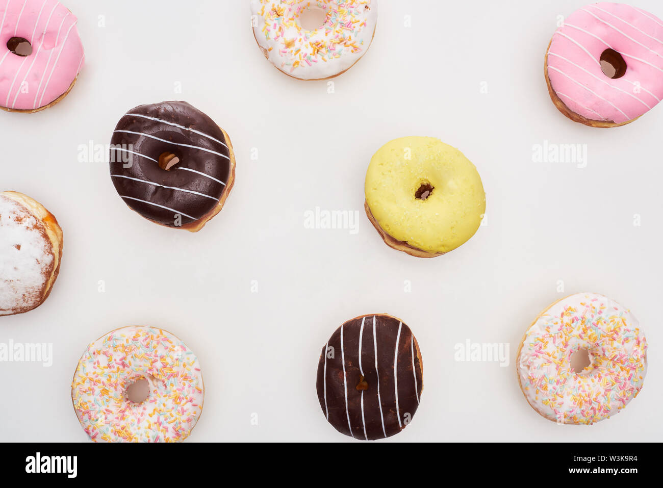 top view of colorful glazed delicious doughnuts on white background ...