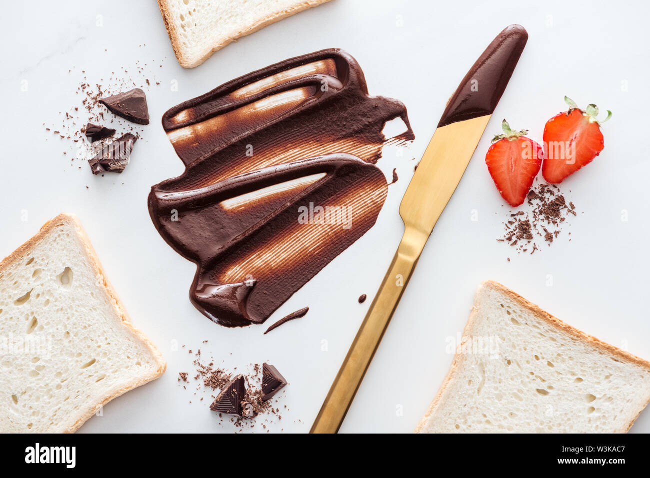 Top View Of Gold Table Knife With Liquid Chocolate Pieces Of