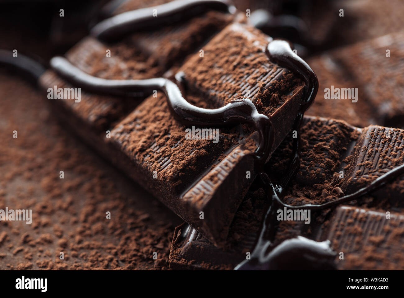 Close up view of pieces of dark chocolate bar with liquid chocolate and ...