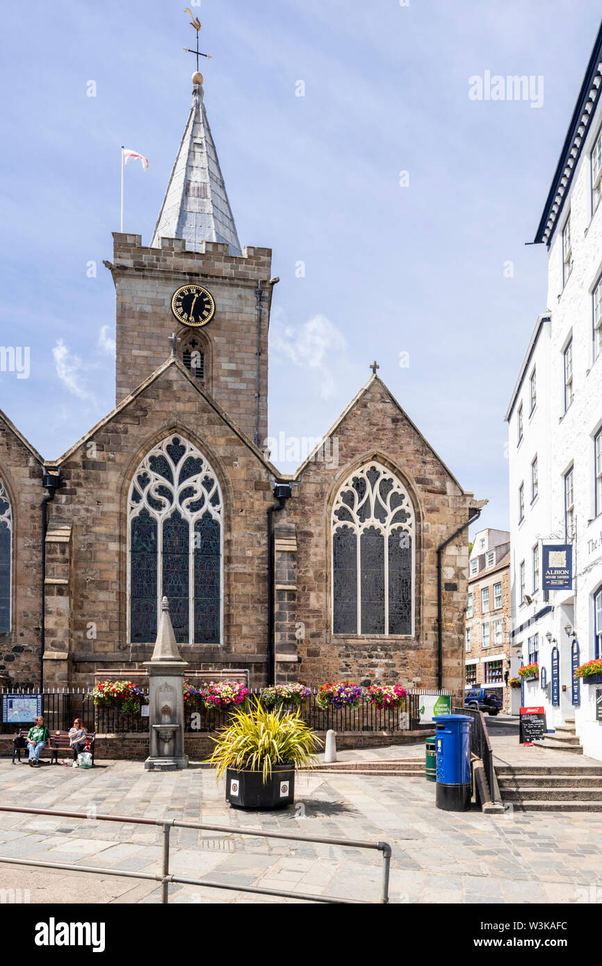 A blue post box in front of Town Church opposite the harbour at St Peter Port, Guernsey, Channel Islands UK Stock Photo