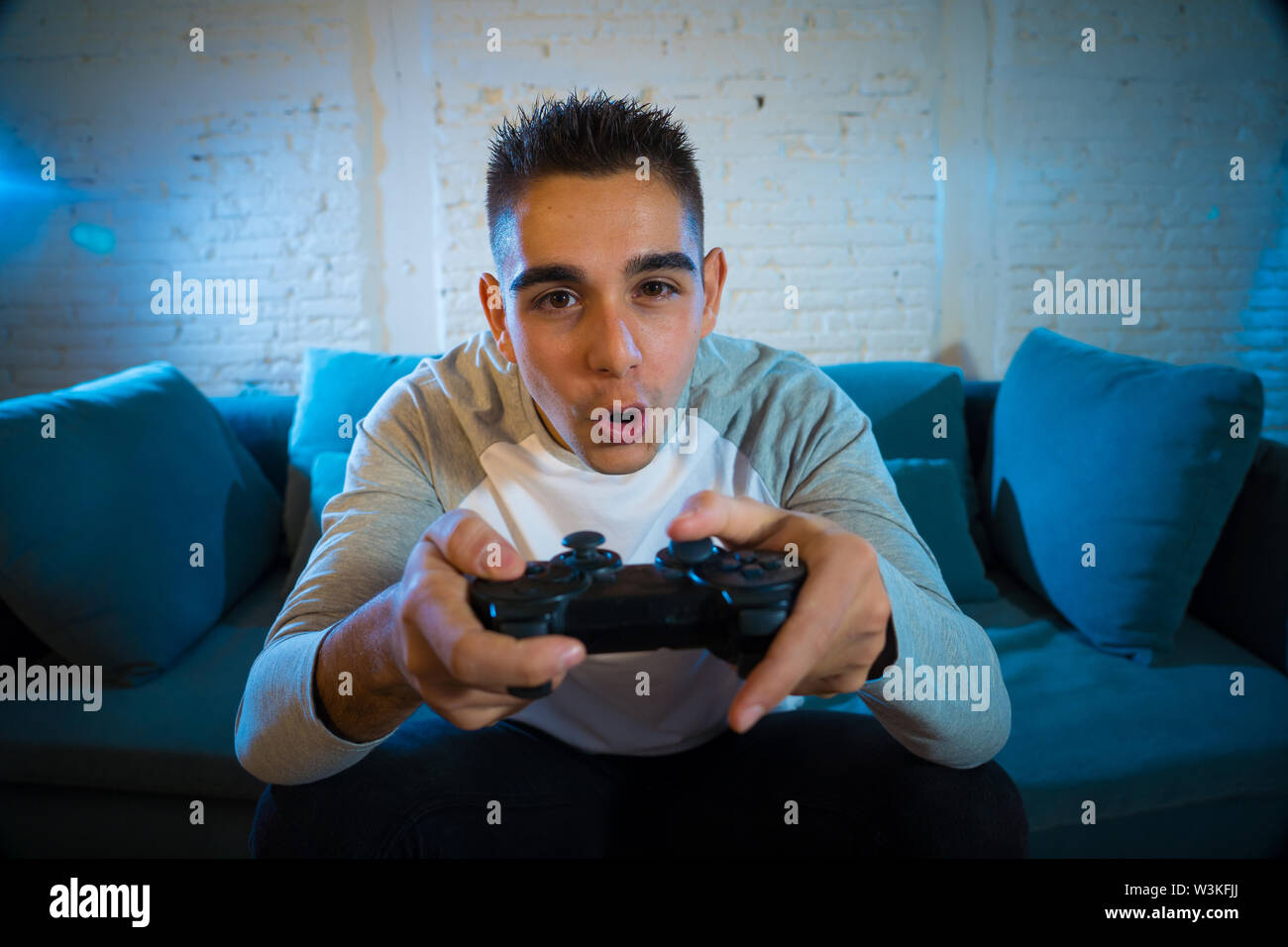 Portrait Of Young Student Man Playing Video Games At Night Using Wireless Remote Joystick With 