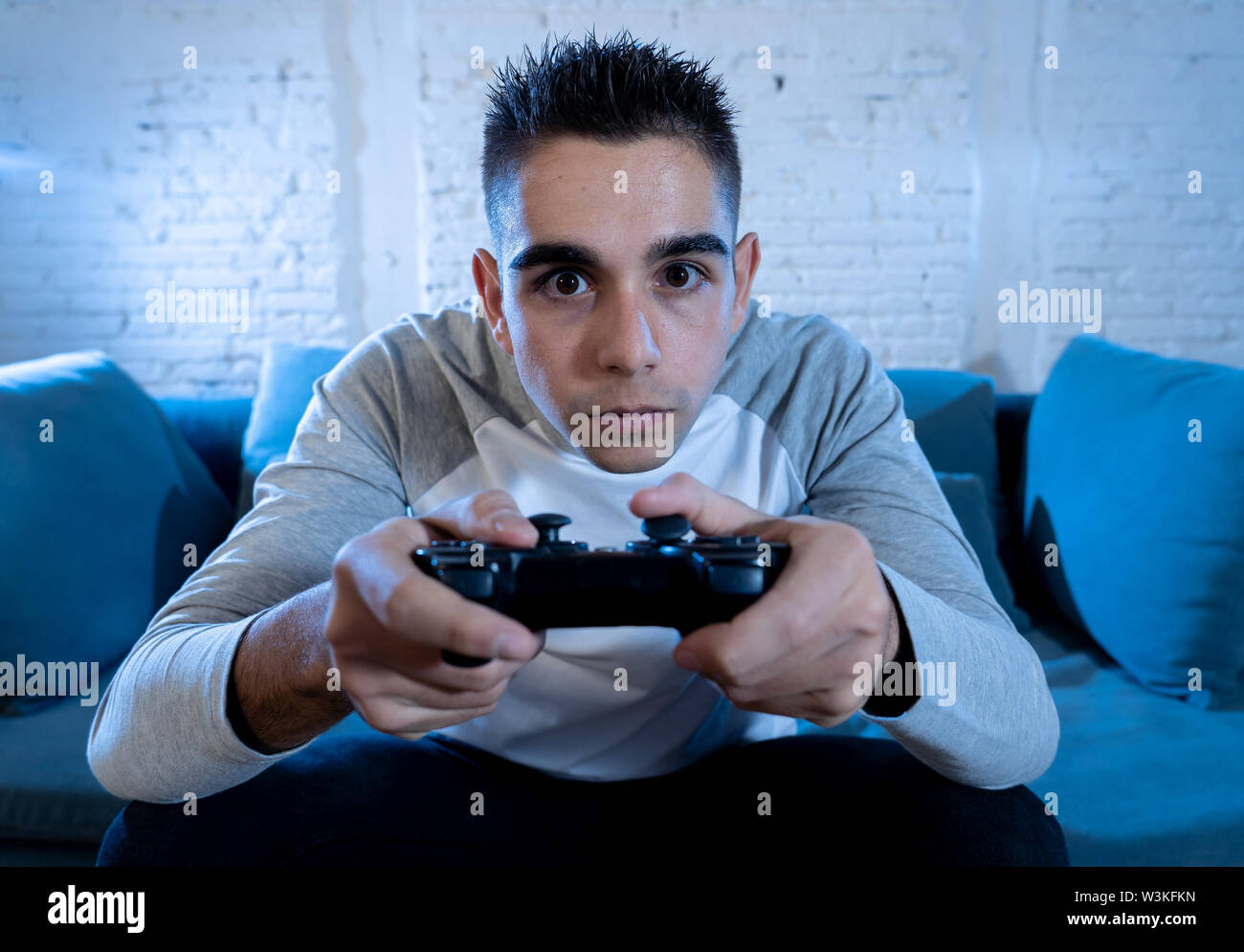 Portrait of young student man playing video games at night using ...