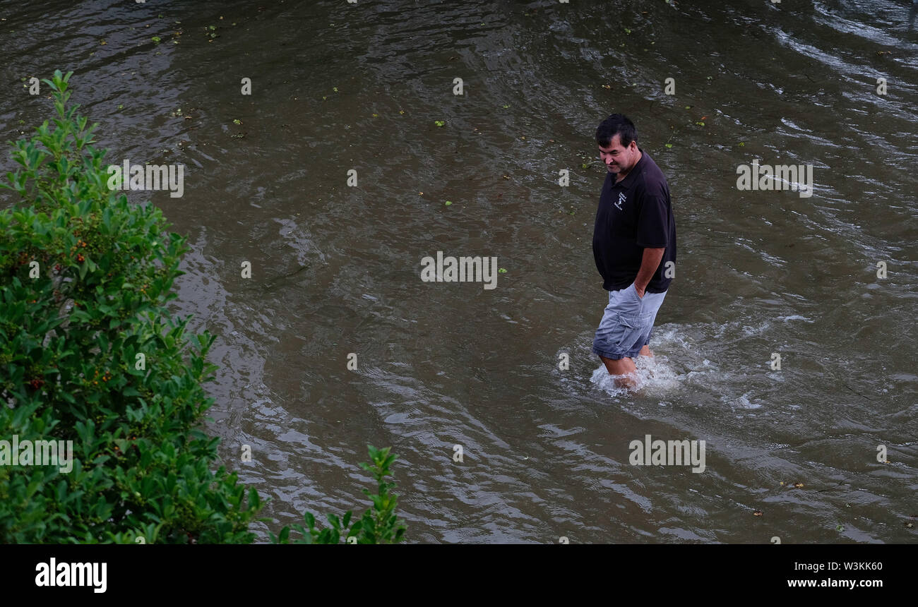 July 13, 2019 - Mandeville, LOUISIANA, U.S - Chris Ladner walks through a flooded road next to Lake Pontchartrain in Mandeville, Louisiana USA as Hurricane Barry makes landfall on July 13, 2019. (Credit Image: © Dan Anderson/ZUMA Wire) Stock Photo