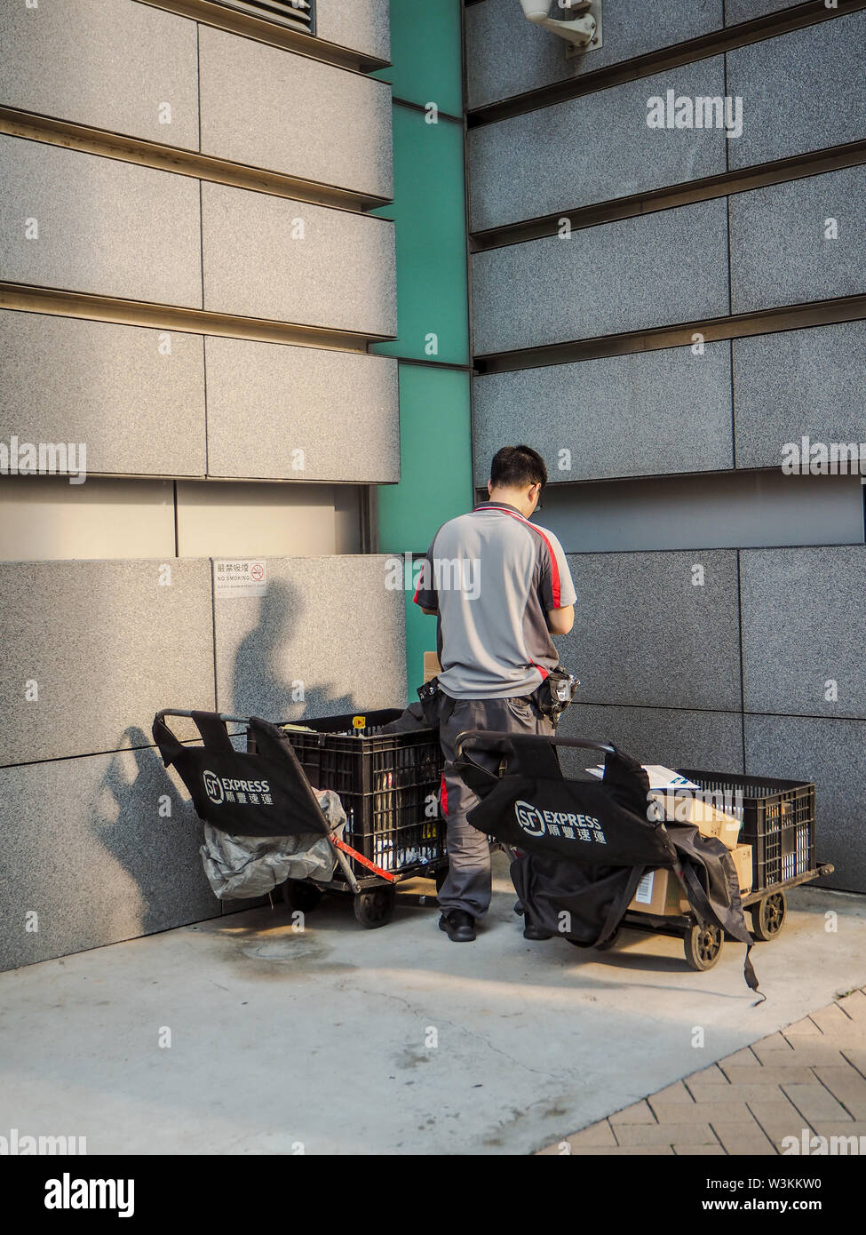 December 2018 - Hong Kong: Mail man working for SF Express, China's second largest express courier company, based in Shenzhen Stock Photo