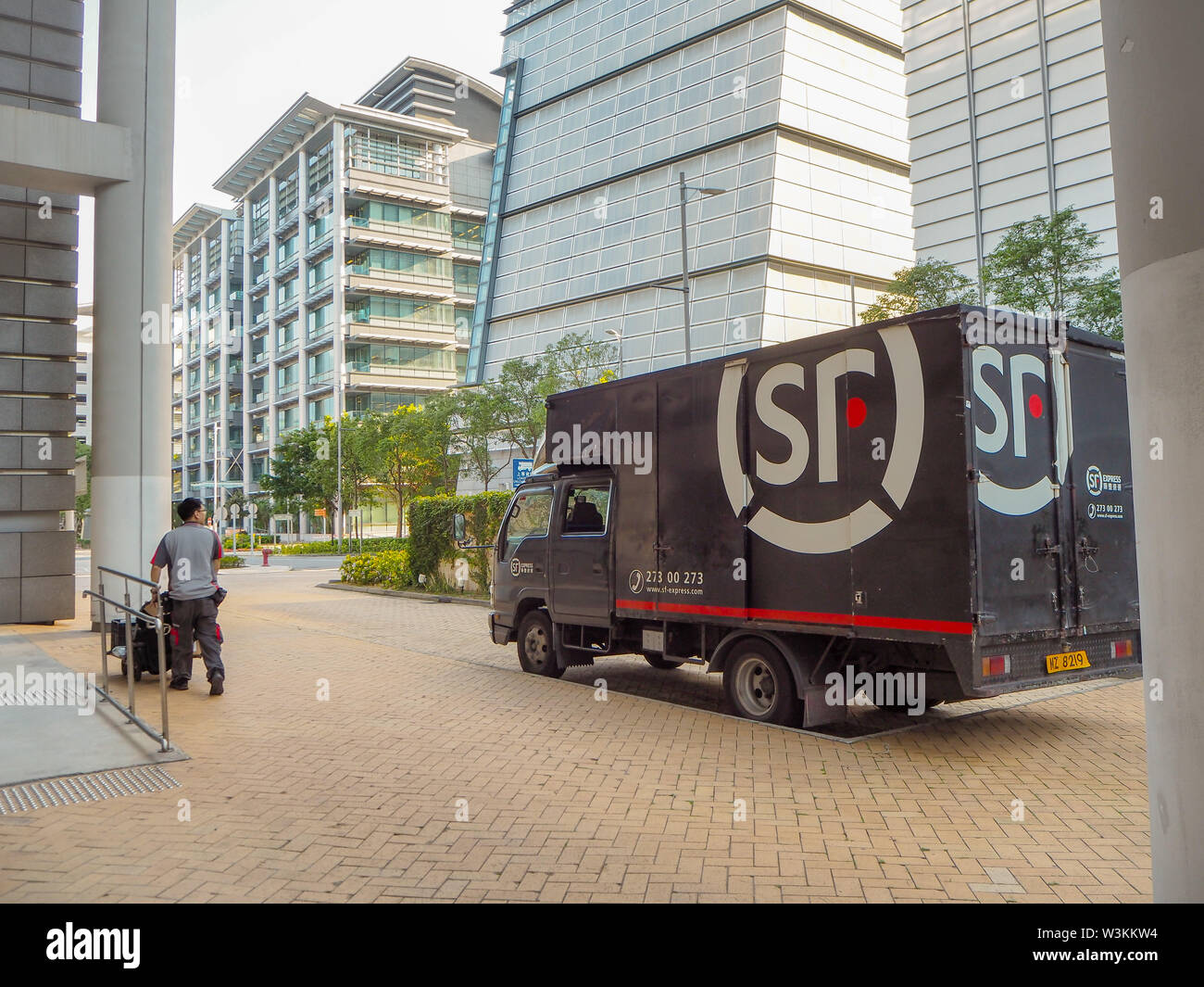 December 2018 - Hong Kong: Small truck and mail man from SF Express, China's second largest express courier company based in Shenzhen Stock Photo