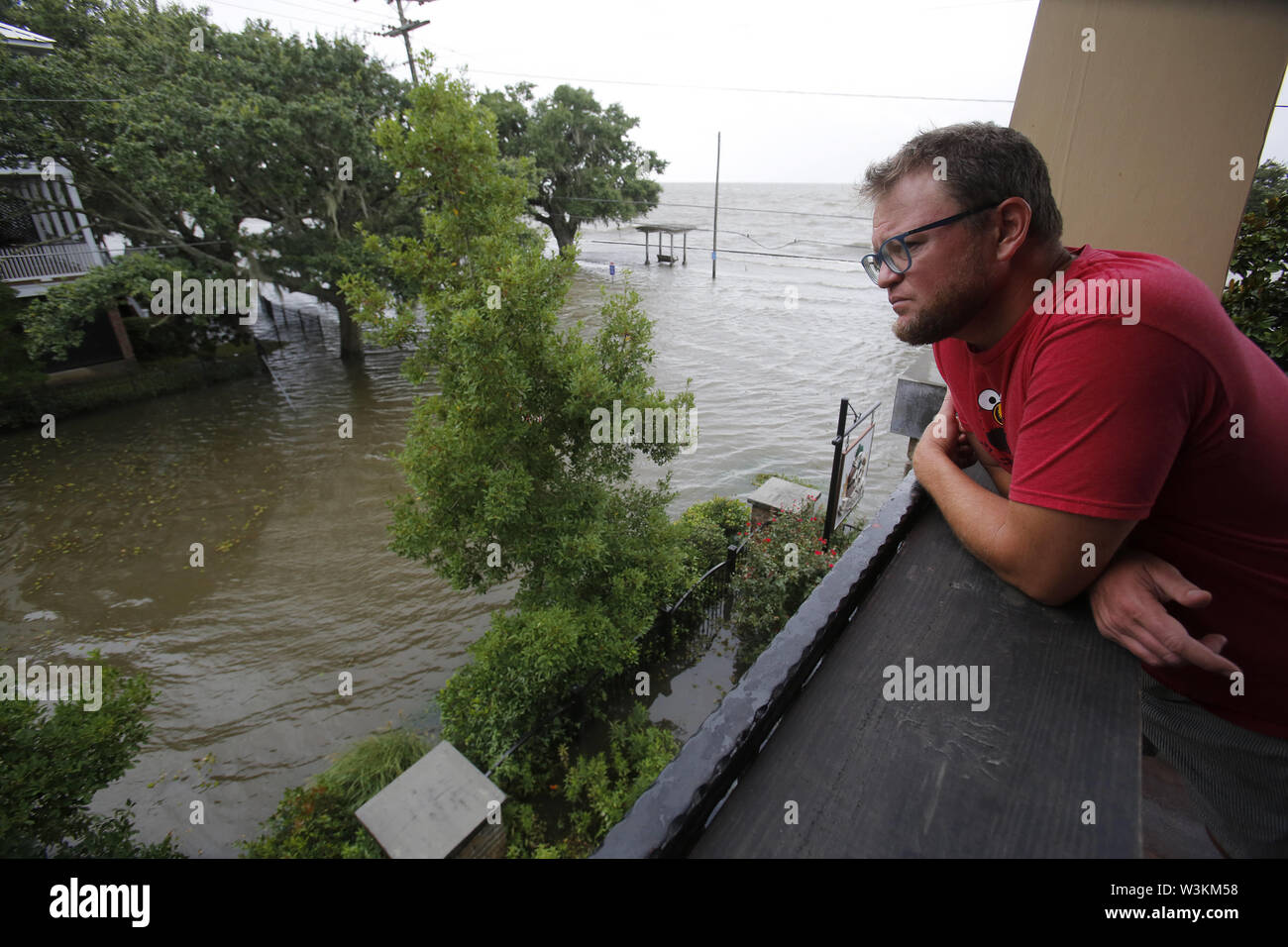 Mandeville, LOUISIANA, USA. 13th July, 2019. Shane Matter looks down on a flooded road from the second story of a local restaurant near Lake Pontchartrain in Mandeville, Louisiana USA as Hurricane Barry makes landfall on July 13, 2019. Credit: Dan Anderson/ZUMA Wire/Alamy Live News Stock Photo