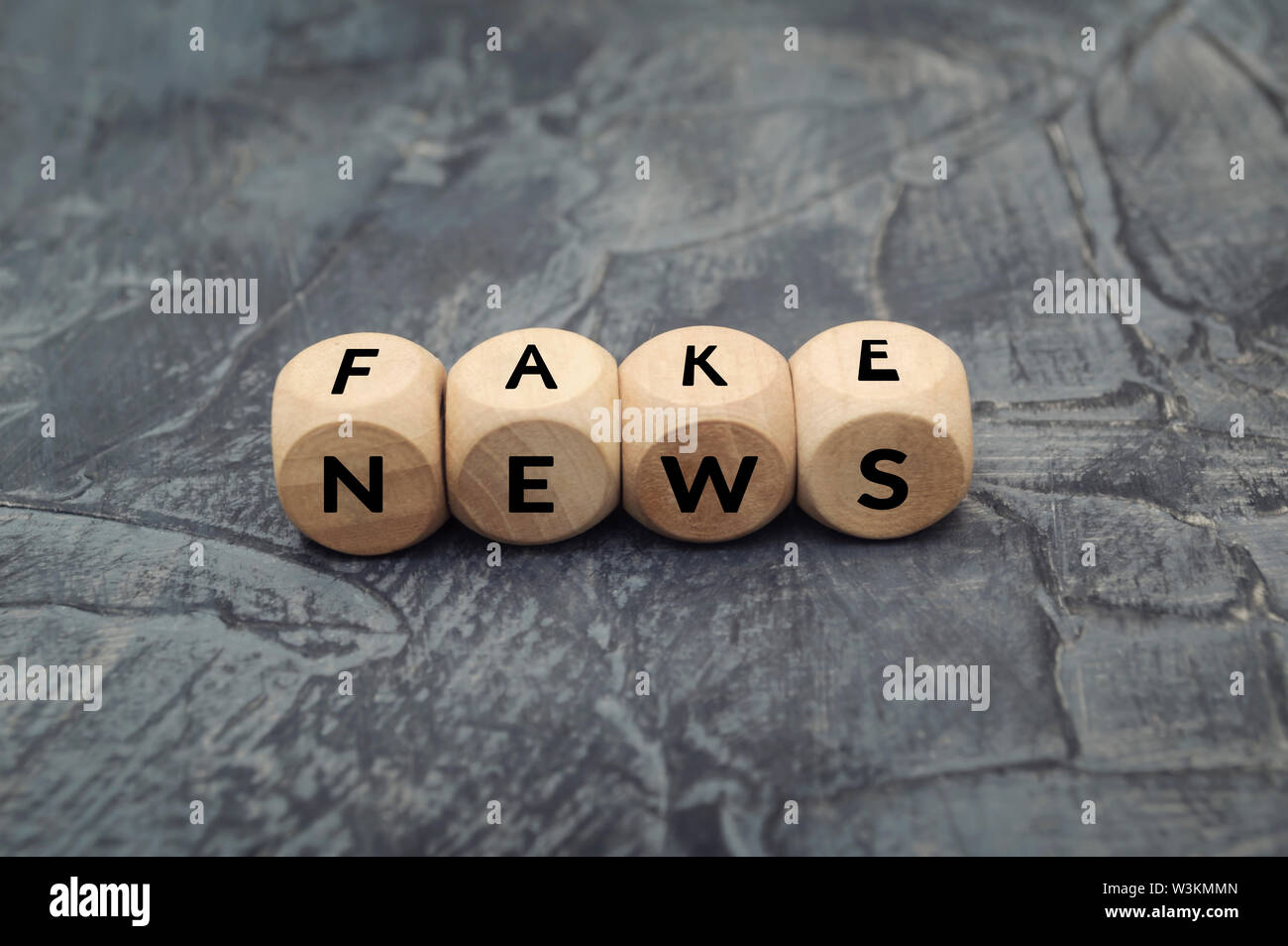 Wooden cube with word  FAKE NEWS on dark background. Propaganda and disinformation. Media and internet concept. Stock Photo