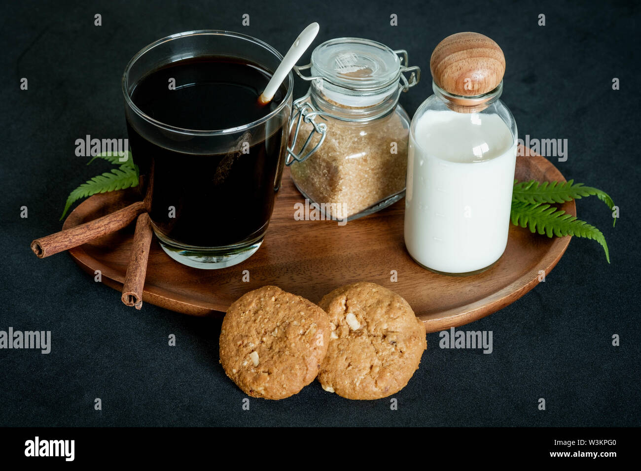 Glass of coffee with brown sugar and milk cookies and cinnamon Stock Photo