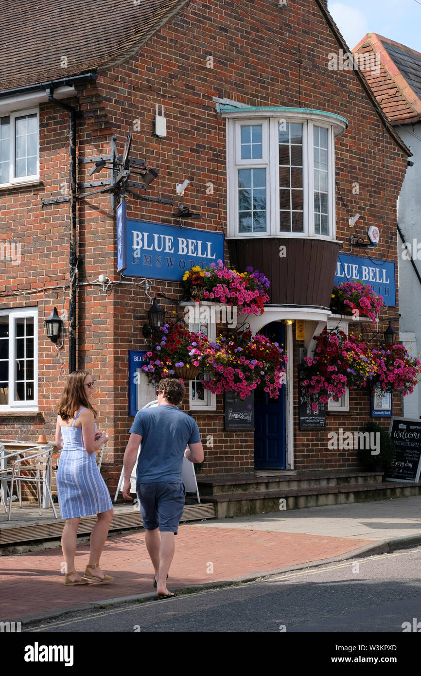 Emsworth, Hampshire,England, UK. A couple of tourists walking past the Bluebell pub. Stock Photo
