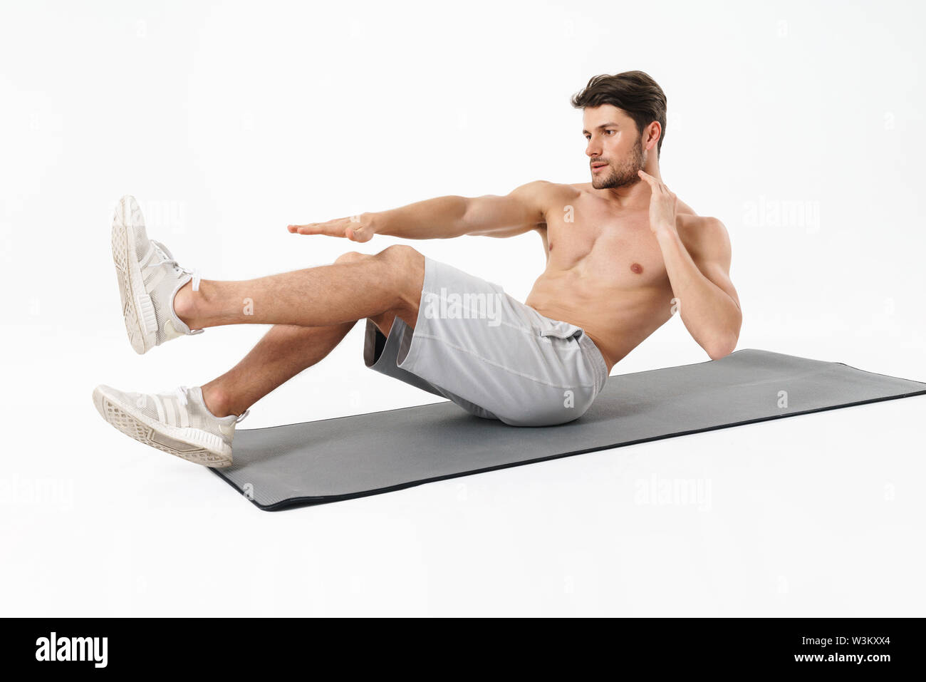 Photo of young shirtless man lying on fitness mat and doing criss cross  crunches while working out isolated over white background Stock Photo -  Alamy
