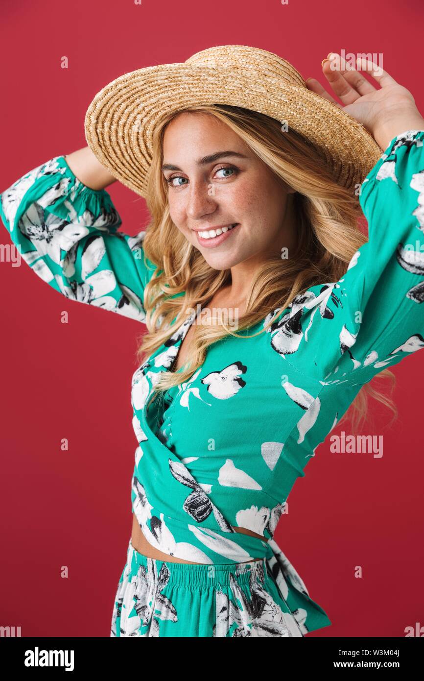 Attractive young blonde woman wearing summer dress and straw hat ...
