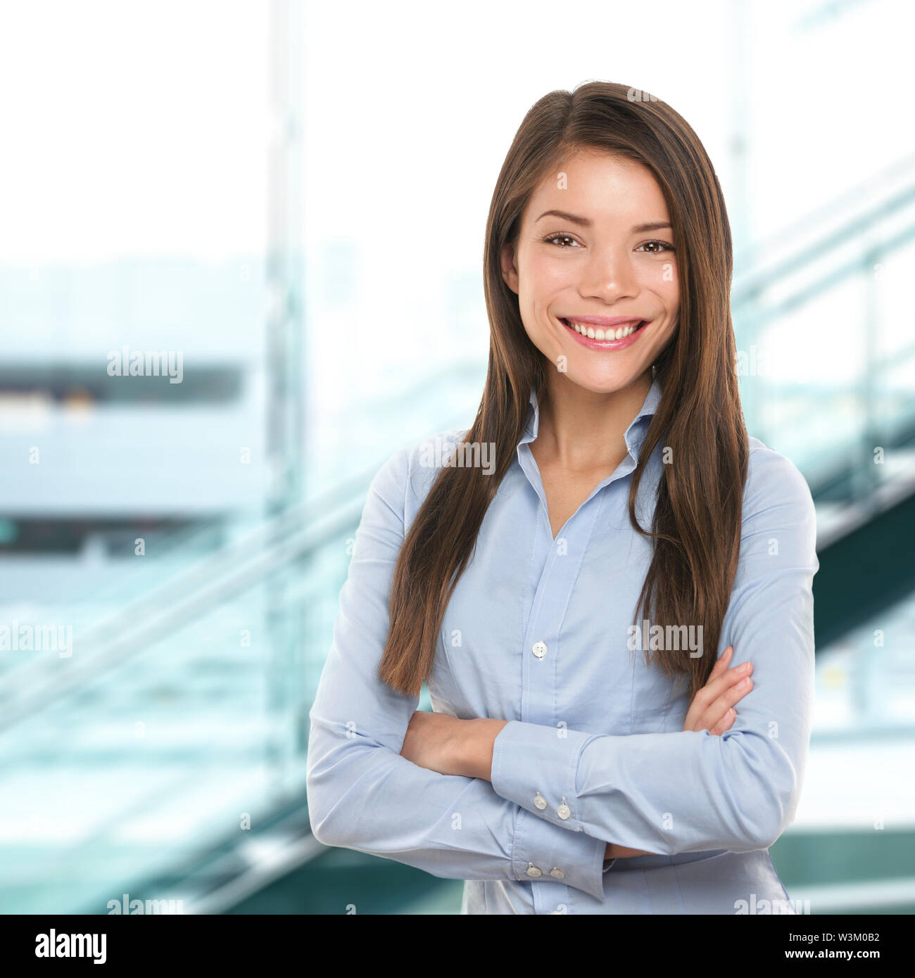 Successful business woman confident portrait. Female businesswoman standing proud and cross-armed looking at camera. Multiracial Asian Chinese / Caucasian female in her 20s. Stock Photo