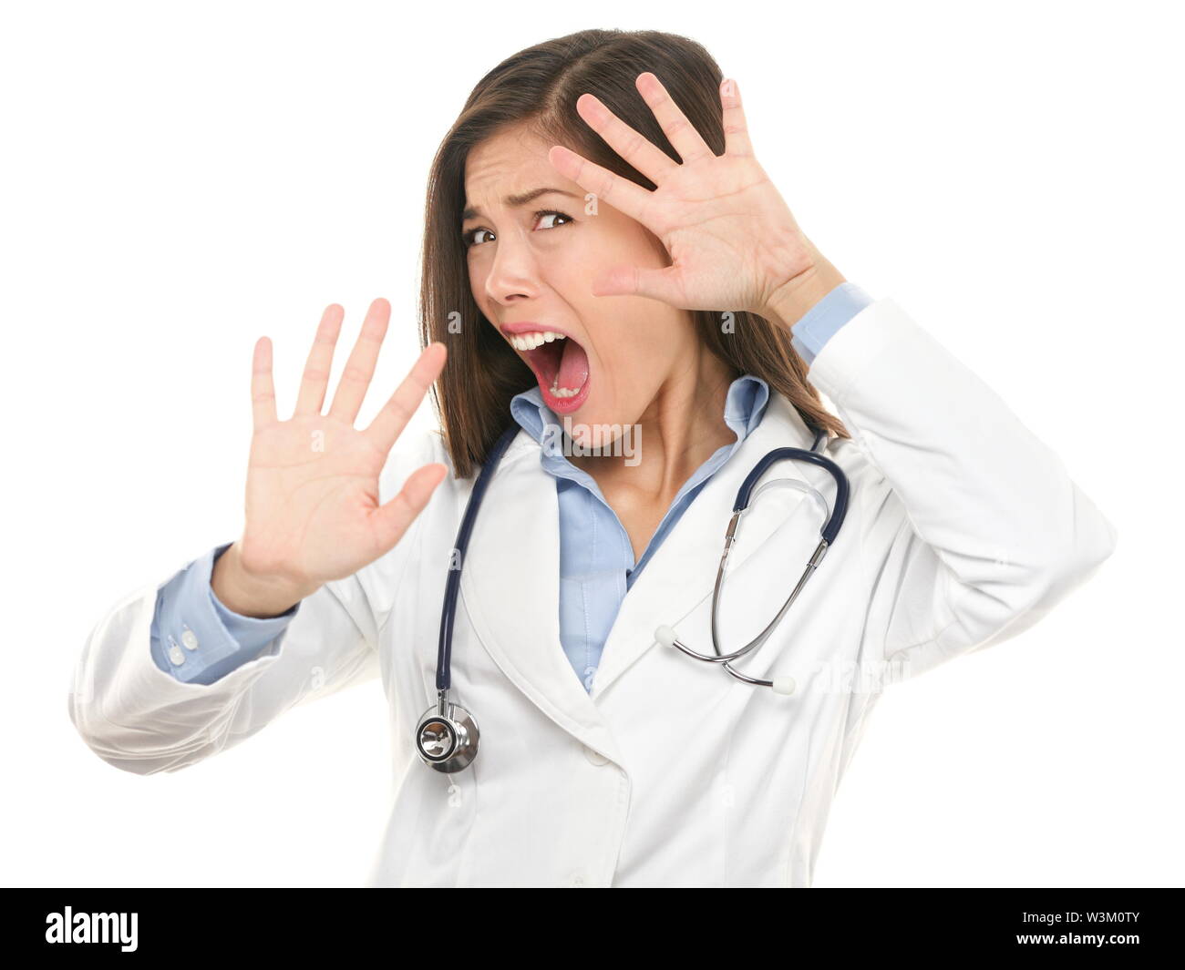 Screaming scared doctor woman afraid and frightened covering her face with hands showing funny expression shocked and surprised. Female medical health care professional isolated on white. Stock Photo