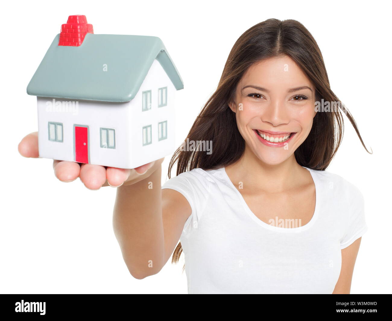 Home / house. Buying new home concept - woman holding mini house. House mortgage and happy home owner conceptual image with multi-ethnic Asian Chinese / Caucasian female model isolated on white background Stock Photo