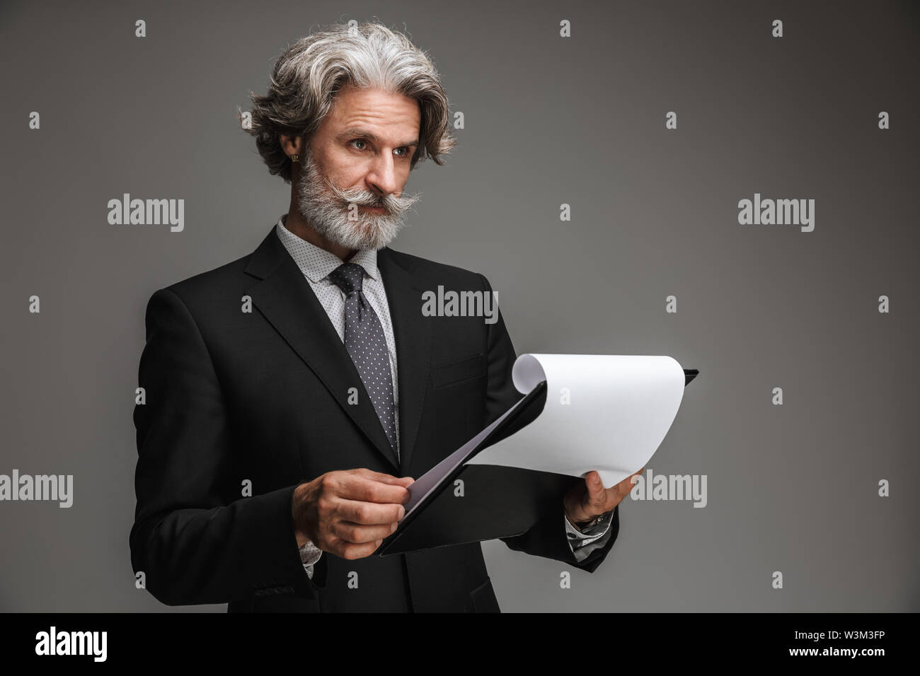 Image of confident adult businessman wearing formal black suit holding ...