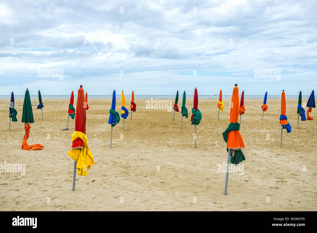 Multicolored Closed Beach Umbrellas Or Parasols Standing In The Sand At 