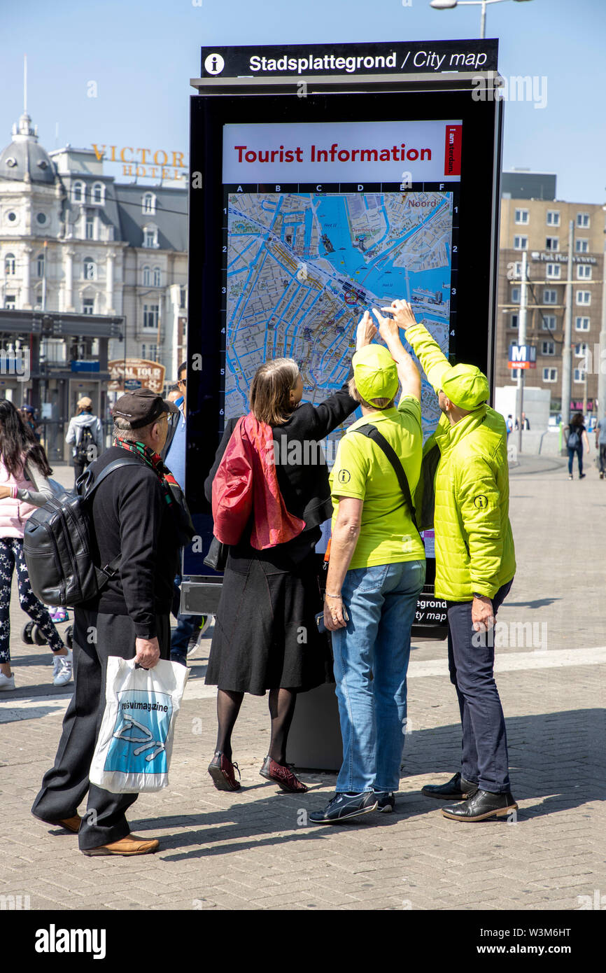 Amsterdam, the Netherlands, downtown, tourists inform themselves on a city map, with the help of helpers of the Tourist Information, Stock Photo