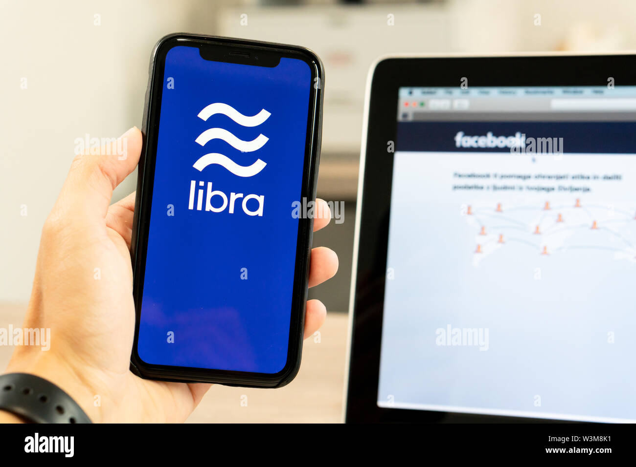 Facebook Libra is a new crypto currency. The photo of smartphone with  Facebook logo on tge screen and the Libra logo on the broshure next to it  Stock Photo - Alamy