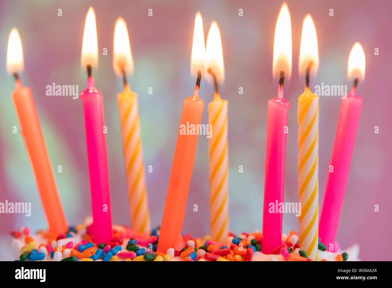 Lit candles on birthday cake Stock Photo Alamy