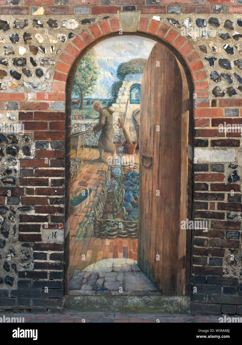 Trompe-l'œil painting in old brick wall gate depicting entrance to Greyfriars Franciscan Friary, Friars Walk, Lewes, East Sussex, England, UK. Stock Photo