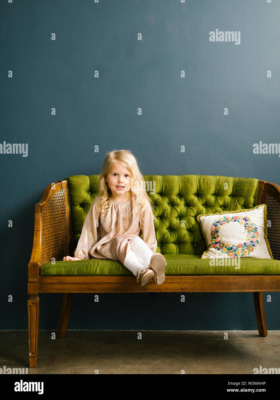 Girl sitting on green sofa Stock Photo