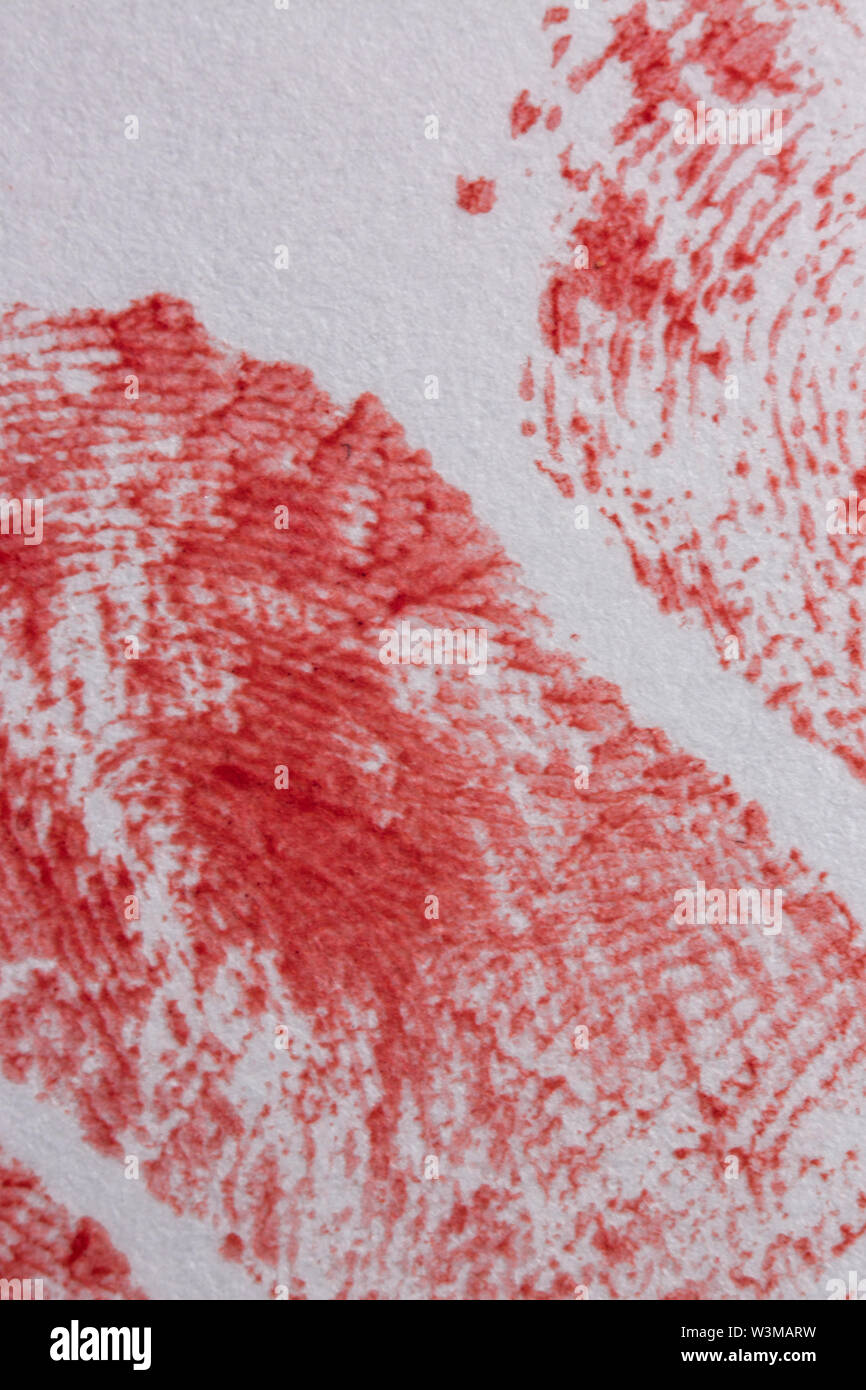 Extreme close up of bloody fingerprints on the white paper. Stock Photo