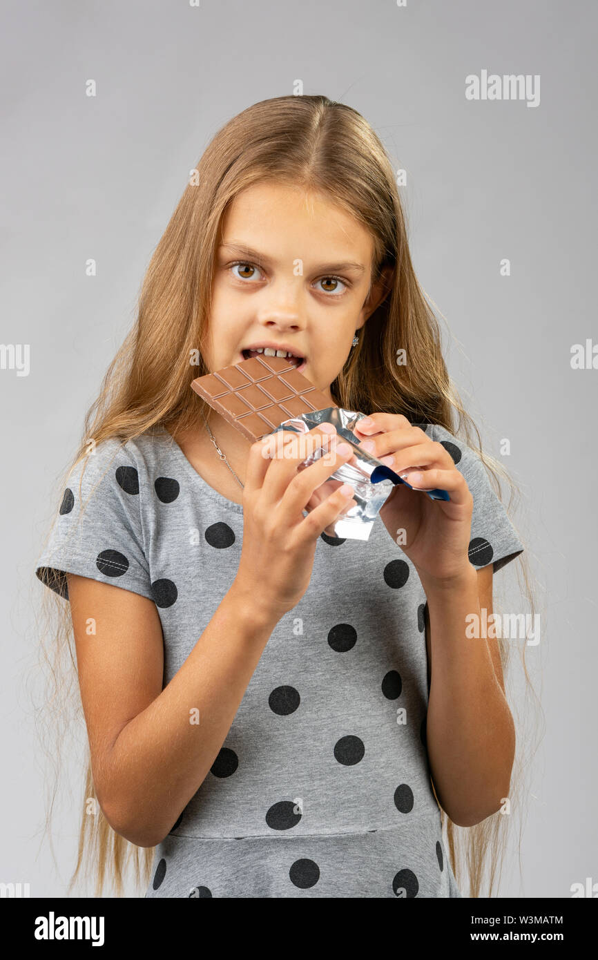 A ten-year-old girl eats a chocolate bar Stock Photo - Alamy