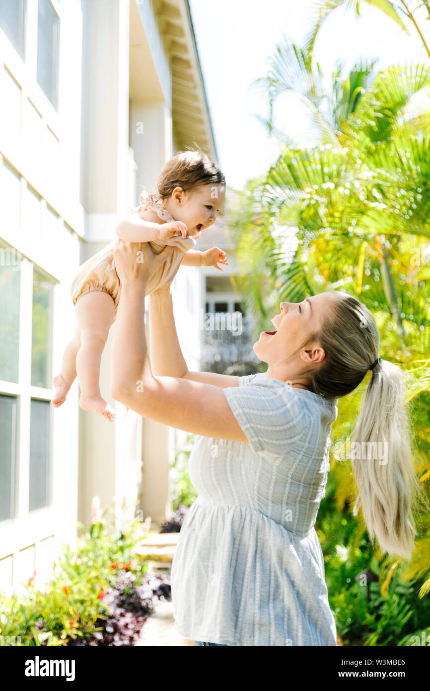 Woman lifting baby daughter Stock Photo