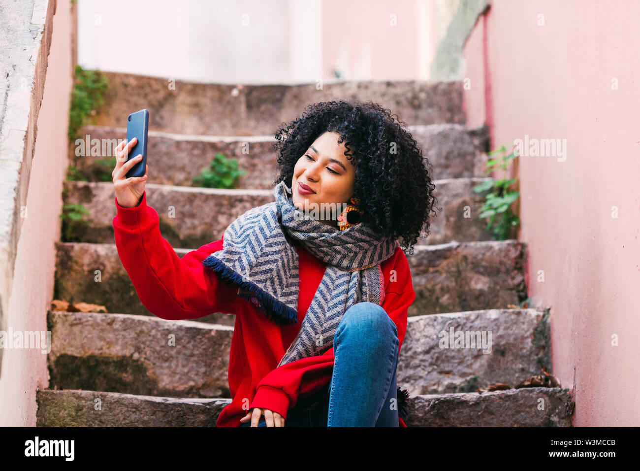 Young woman taking selfie on steps Stock Photo