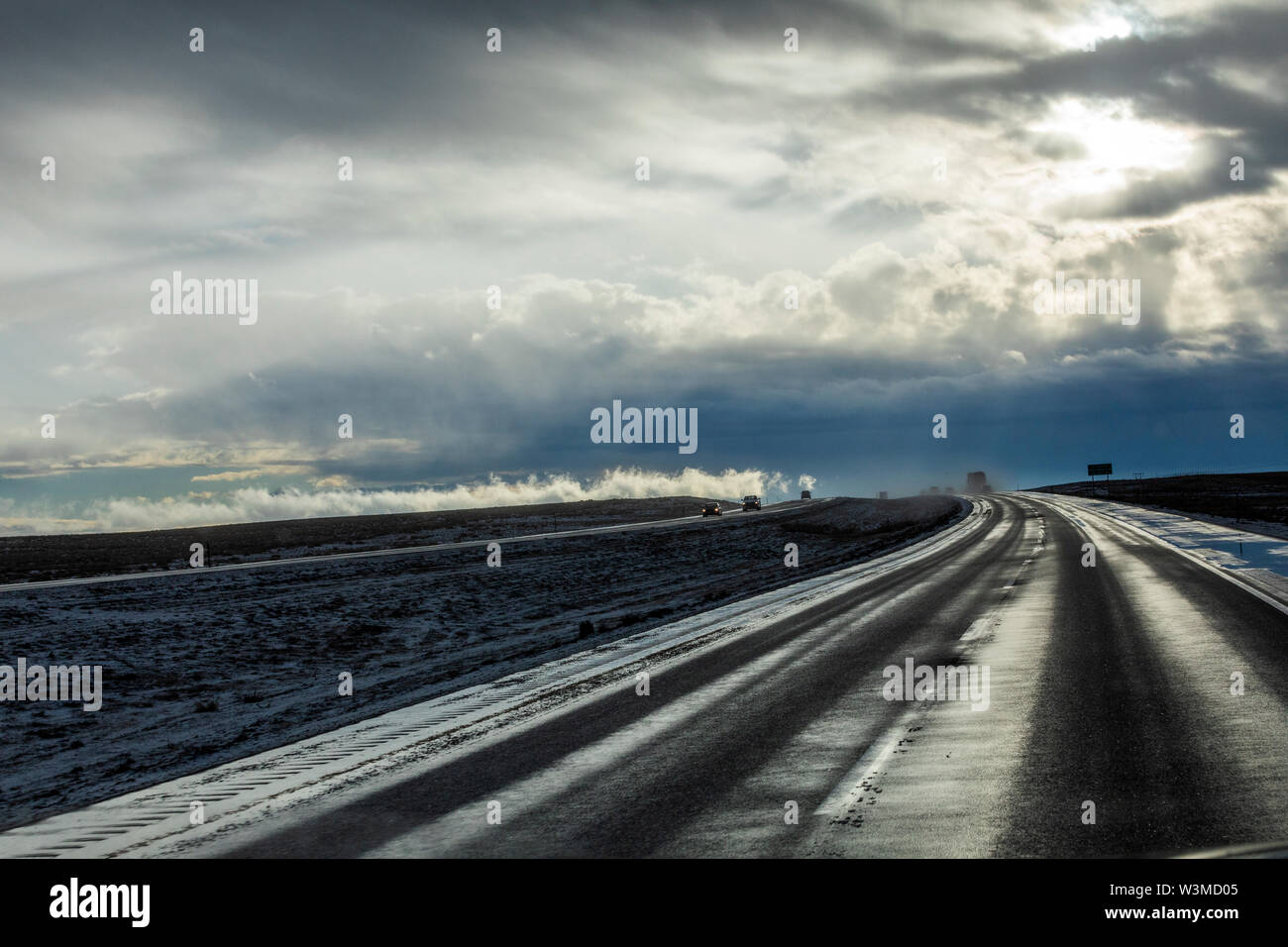 Country road with snow under overcast sky Stock Photo