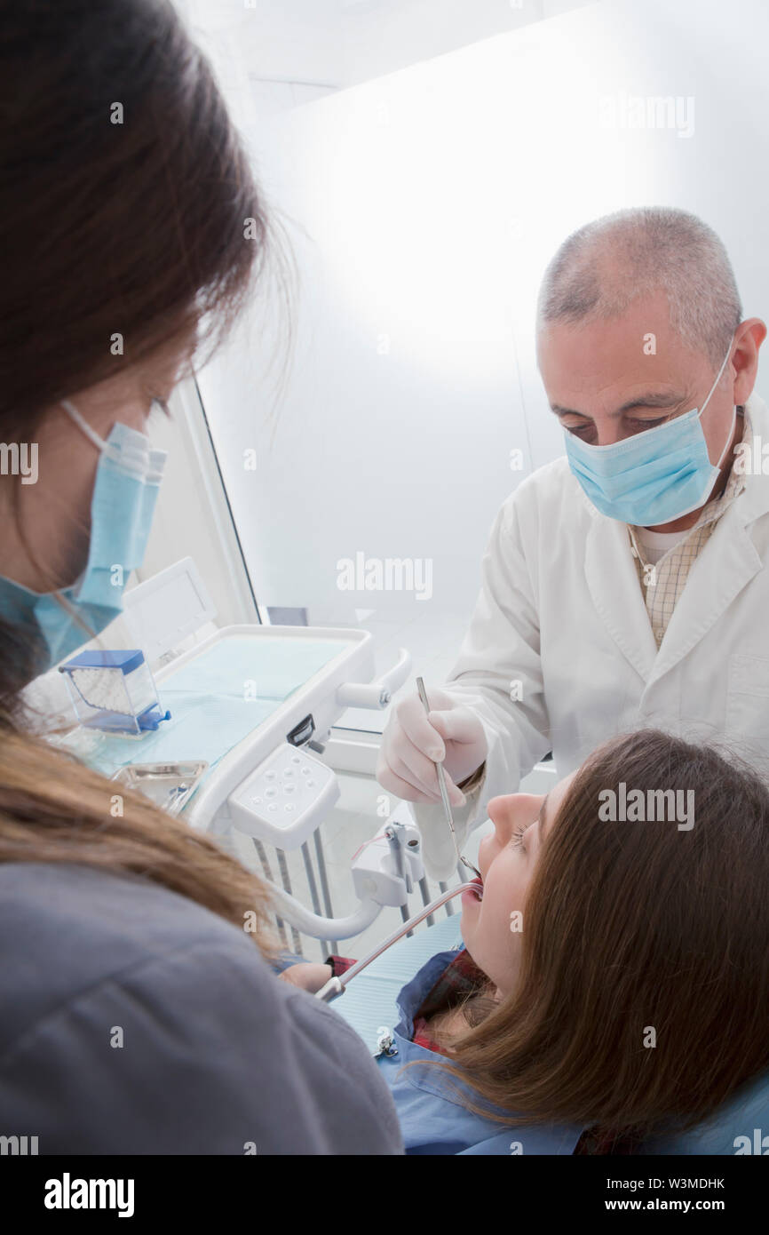 Dentist and hygienist cleaning patient's teeth Stock Photo
