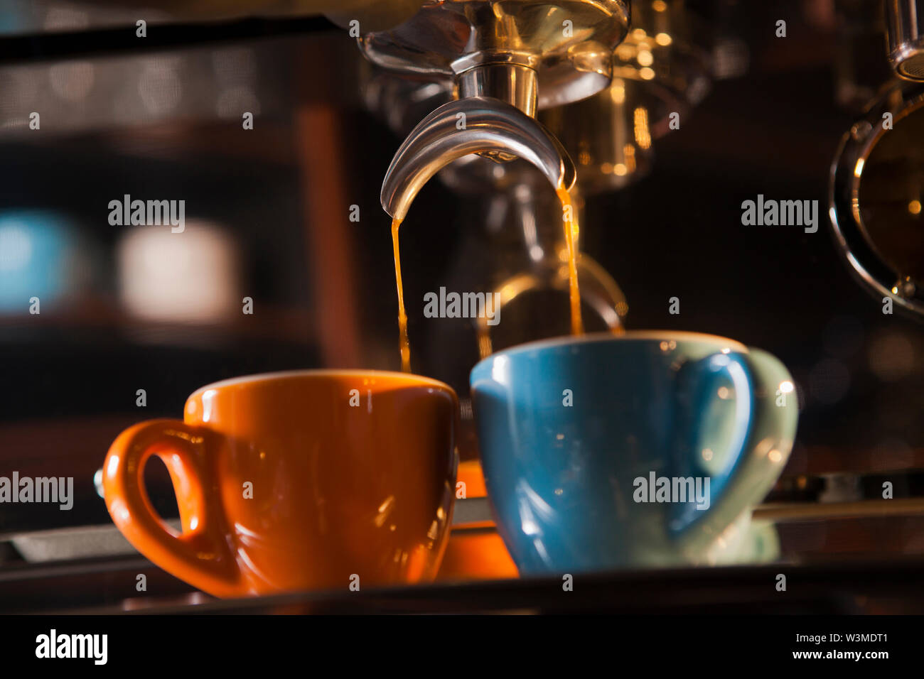 Two espresso cups getting filled in a portafilter machine Stock Photo -  Alamy