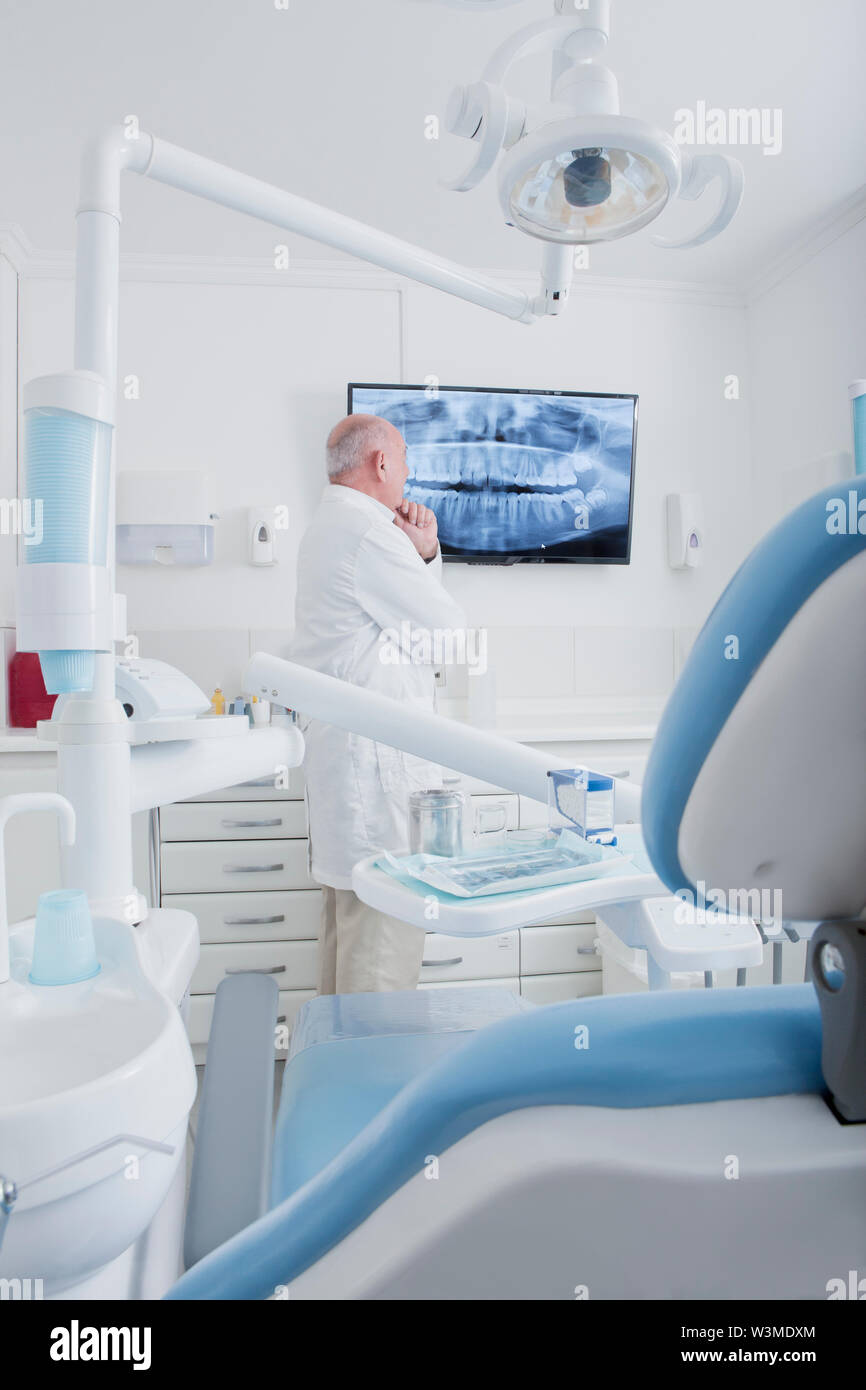 Dentist examining X-ray on television screen Stock Photo