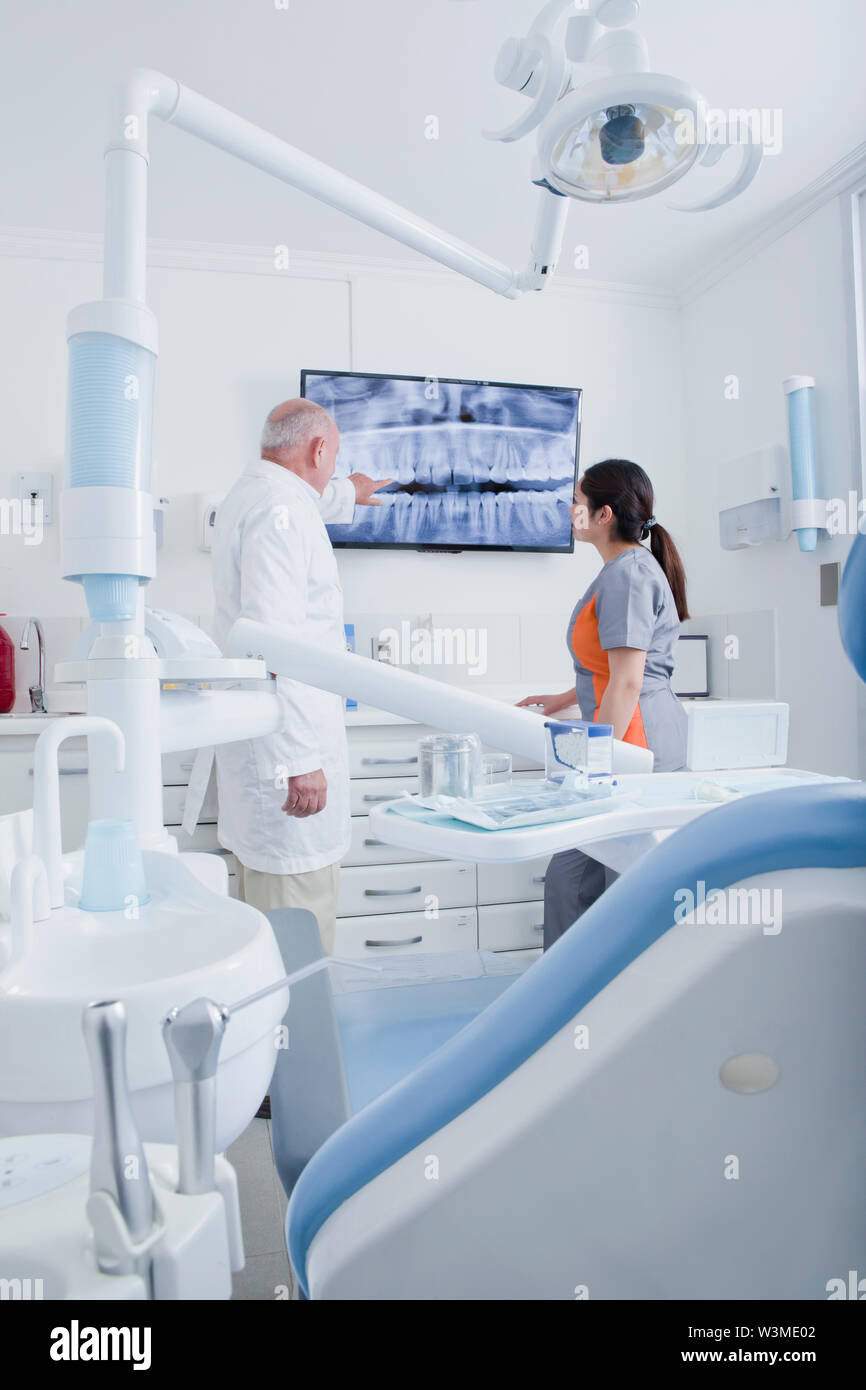 Dentist and dental hygienist examining Xray on television screen Stock