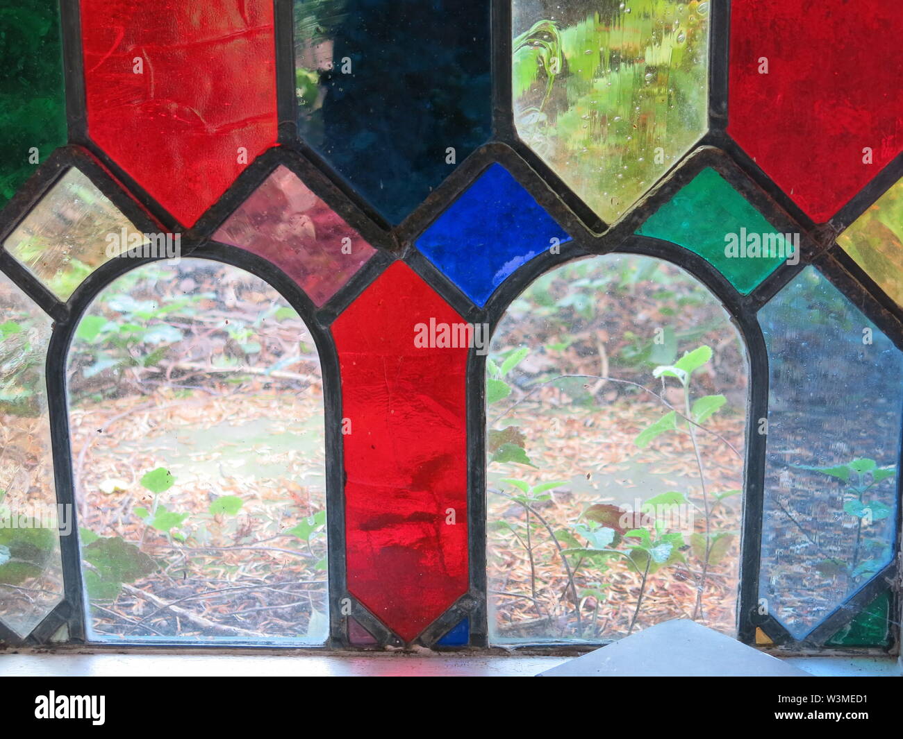 In a stained glass window of geometric shapes, two arches of clear