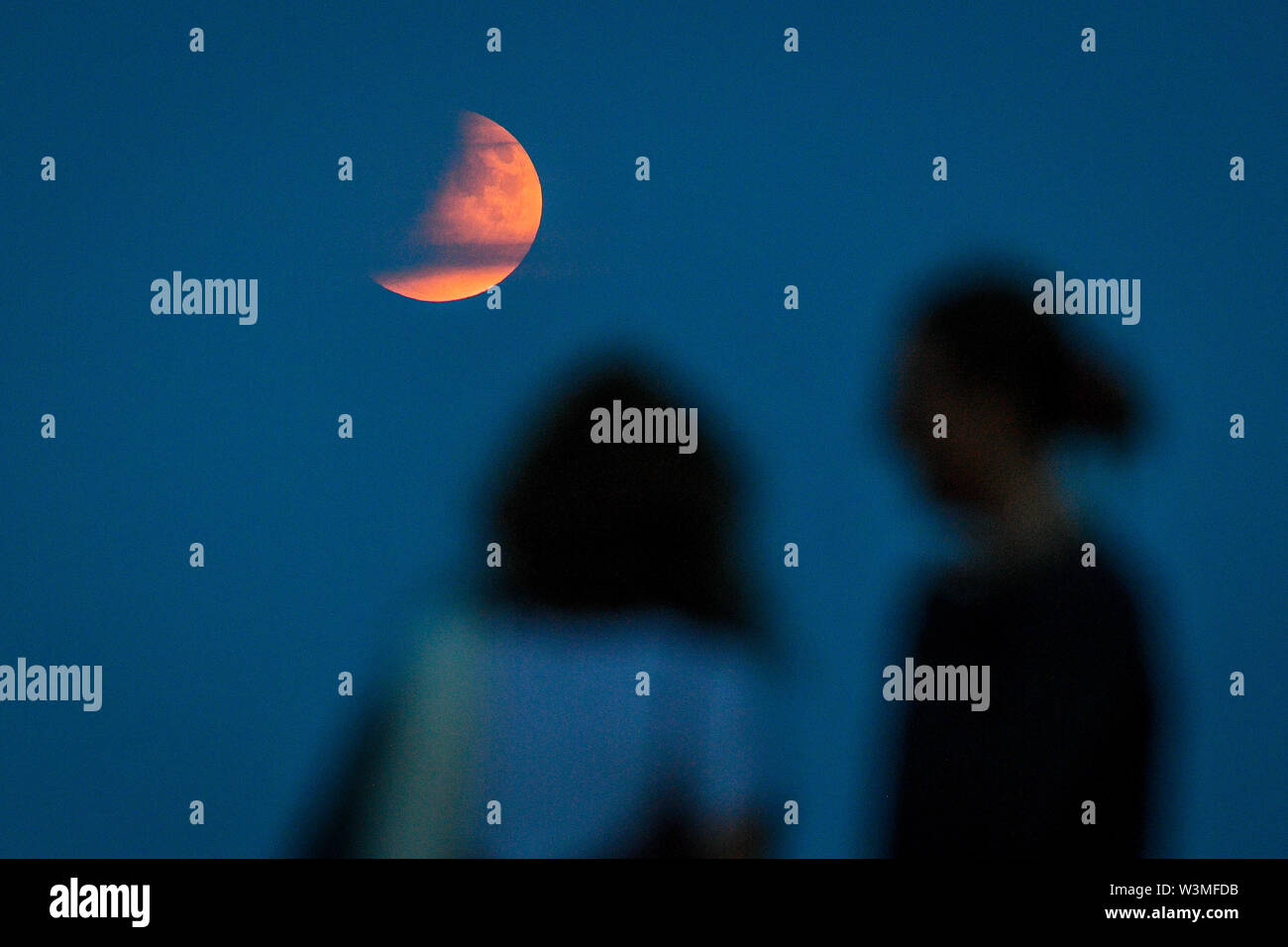 People watch the partial lunar eclipse from the esplinade in Sidmouth ...