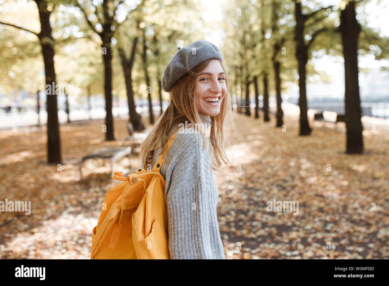 Young woman with yellow backpack in park in Berlin, Germany Stock Photo ...